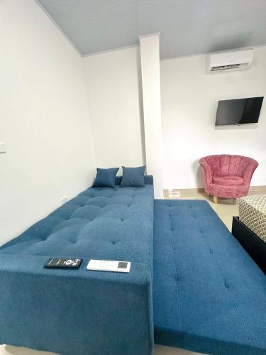 a large blue bed in a room with a tv at Sol caribe aptos in Santiago
