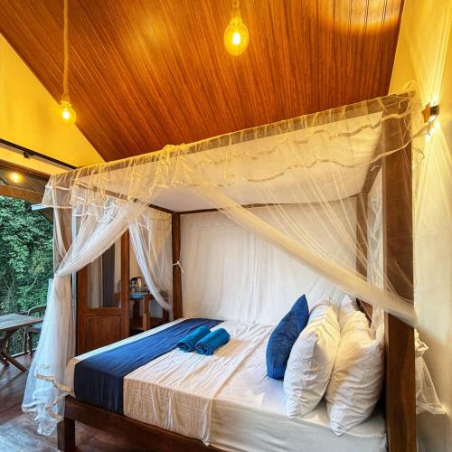 a bedroom with a canopy bed with blue pillows at Forest River Escape Ella in Ella