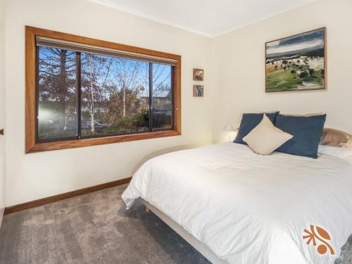 a bedroom with a bed and a window at Alpine Digs in Jindabyne