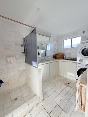 a large bathroom with a shower and a sink at The Balcony at Airlie in Airlie Beach