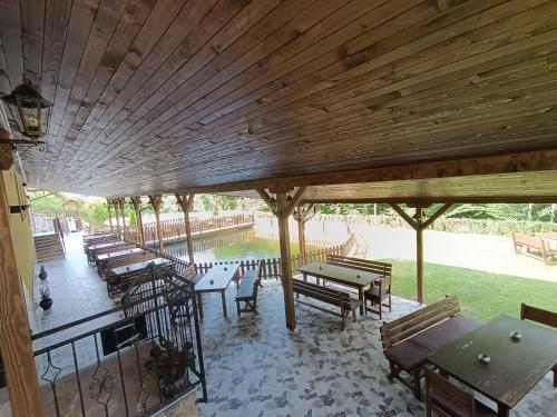 a large wooden pavilion with tables and benches at Комплекс Кантона in Razhishte