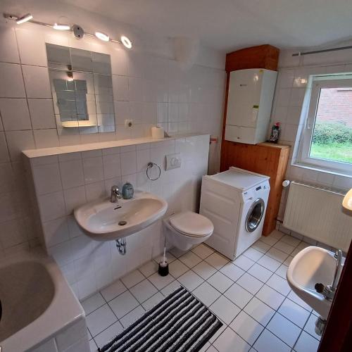 a white bathroom with a sink and a toilet at Mammut Cottage in Balve