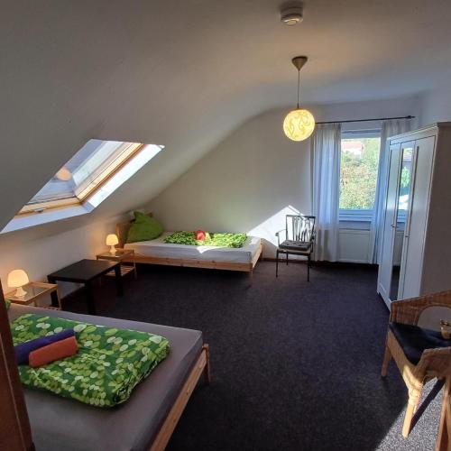 a attic room with two beds and a window at Mammut Cottage in Balve