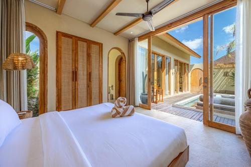 a teddy bear sitting on a bed in a bedroom at 1 BR Private Pool Villa for Two - Casa Manja in Krambitan