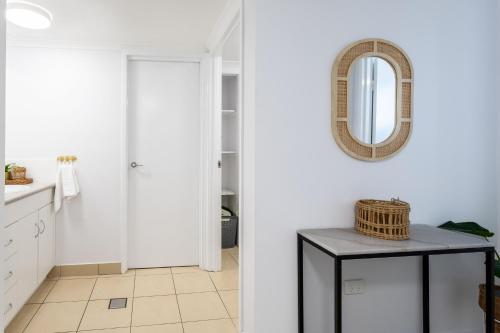a bathroom with white walls and a mirror on the wall at Sea Air 2 in Yeppoon