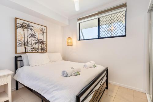 a bedroom with a bed with two stuffed animals on it at Sea Air 2 in Yeppoon