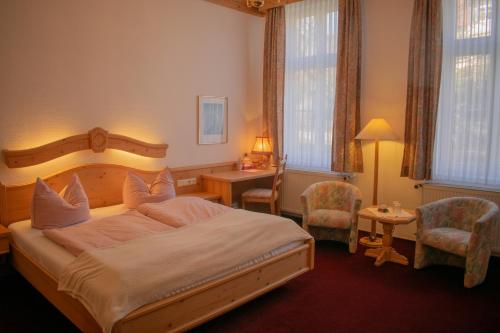 a bedroom with a large bed and a table and chairs at Pension Haus Marga in Wernigerode