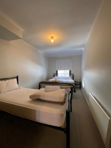 a room with two beds and a window and a room with two beds at Alana Apartment 2 in Falls Creek