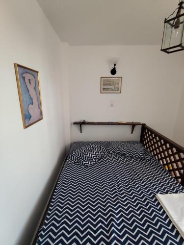 a small bedroom with a bed with blue and white stripes at Asvestoti blue ciel light 2 in Pera Gyalos