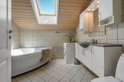 a bathroom with a tub and a sink and a toilet at C11326-Tarm-Sortbaervej-20 in Tarm