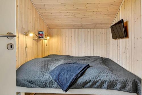 a bedroom with a bed with a tv on the wall at C11326-Tarm-Sortbaervej-20 in Tarm