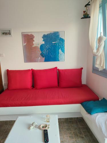 a red couch sitting in a living room at ASVESTOTI MESONETTES BLUE LIGHT ΣΙΕΛ ΜΕΖΟΝΕΤΕs in Pera Gyalos