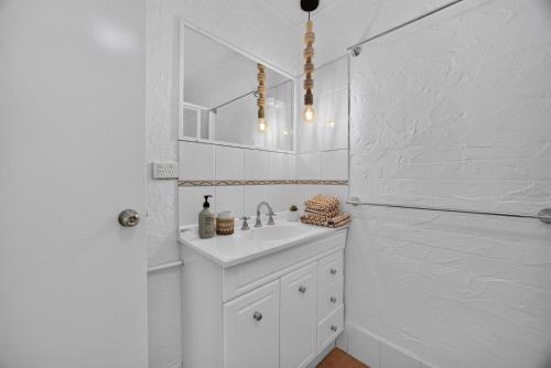 a white bathroom with a sink and a shower at Suntan at Sunshine in Sunshine Beach