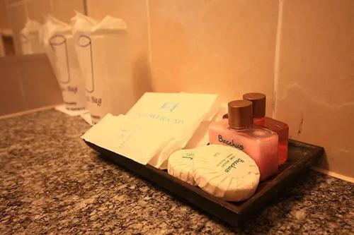 a counter top with a bottle of soap and towels at Bacchus Home Resort Pranburi in Ban Pak Nam Pran