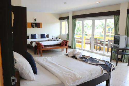 a hotel room with two beds and a balcony at Bacchus Home Resort Pranburi in Ban Pak Nam Pran