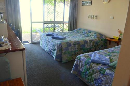 a hotel room with two beds and a balcony at Ocean View Motel Bowen in Bowen