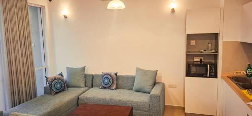 a living room with a couch with pillows on it at MaSa Beach Front harbour view penthouse D12 in Wattala