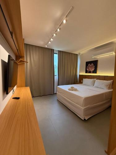 a bedroom with a large white bed in a room at Beira Mar Japaratinga Brisa in Japaratinga