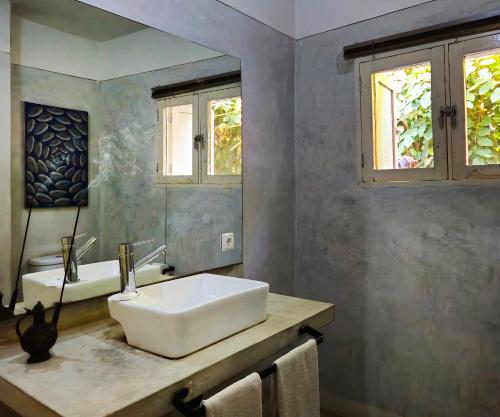 a bathroom with a white sink and a mirror at Guesthouse MALAGUETA INN II in Maputo