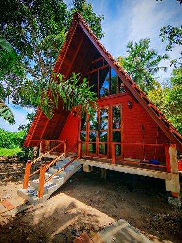 a small red house with a large window at Paddy field Whispering wind Cabin in Ahangama Nakanda