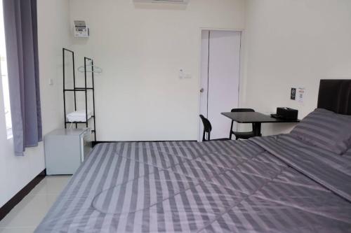 a bedroom with a bed and a desk and a table at Safezone Resort Suanluang in Sathani Ban Hua Mak