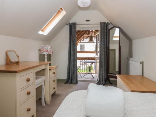 a bedroom with a bed and a desk and a window at Redwoods in Beverley