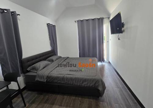 a bedroom with a bed and a television in it at Safezone Resort Suanluang in Sathani Ban Hua Mak