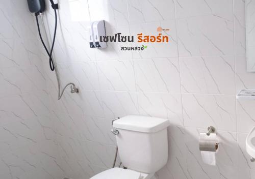 a bathroom with a toilet and a sign on the wall at Safezone Resort Suanluang in Sathani Ban Hua Mak