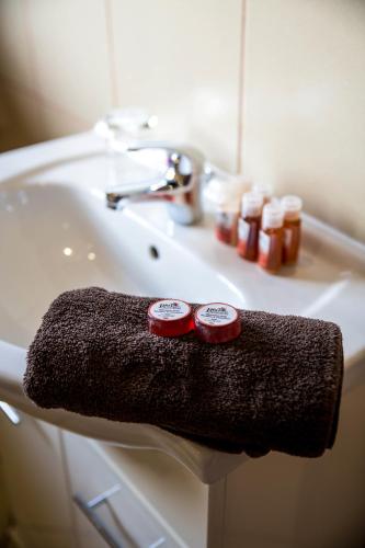 a bathroom sink with two red dishes on a towel at Rustenburg Boutique Hotel in Rustenburg