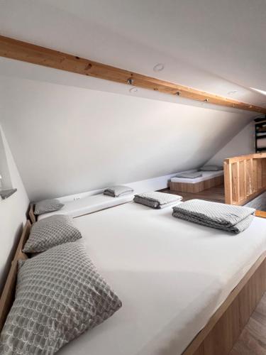 a large white bed with four pillows on it at Sun House Luka in Radmirje