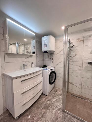 a bathroom with a washing machine and a washer at Sun House Luka in Radmirje