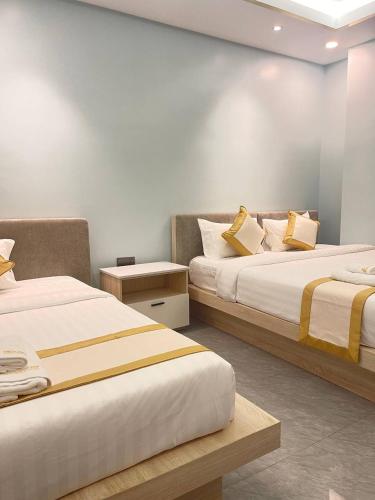 two beds sitting next to each other in a room at Khemra Kampot Hotel in Kampot in Kampot