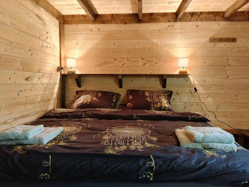 a bedroom with a bed in a wooden wall at Chata za Świerkami in Nowa Ruda