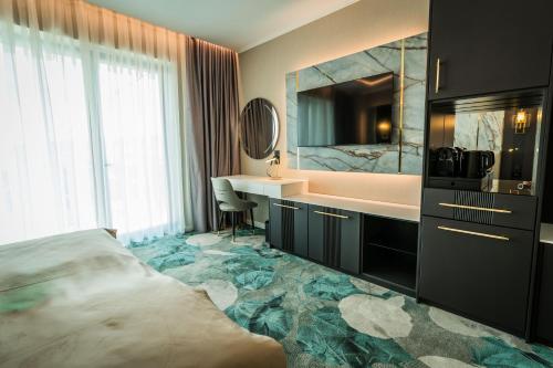 a bathroom with a bed and a sink and a tub at Grand Hotel President in Baile Felix