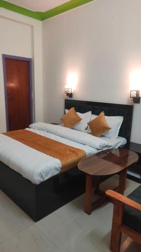 two twin beds in a room with a table at Hotel Park Royal in Pithorāgarh