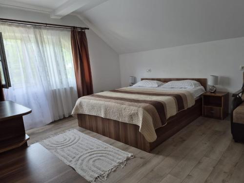 a bedroom with a large bed and a window at Casa Deea in Căpăţîneni-Pămînteni