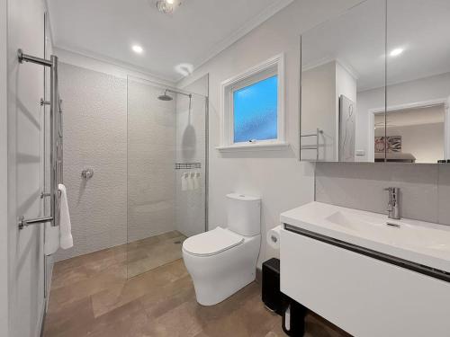 a white bathroom with a toilet and a sink at Gables on Malcolm in Mansfield