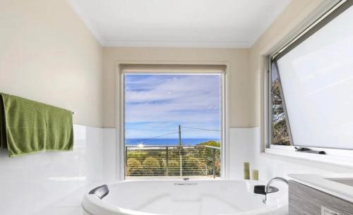 a bathroom with a tub and a large window at Marcail Views Lakes Entrance in Lakes Entrance