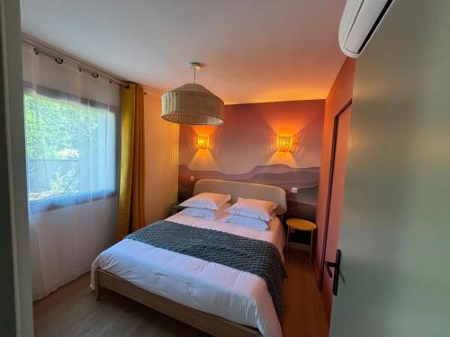 a bedroom with a large bed with two pillows at Résidence les 3 volcans 4 étoiles in Clermont-Ferrand