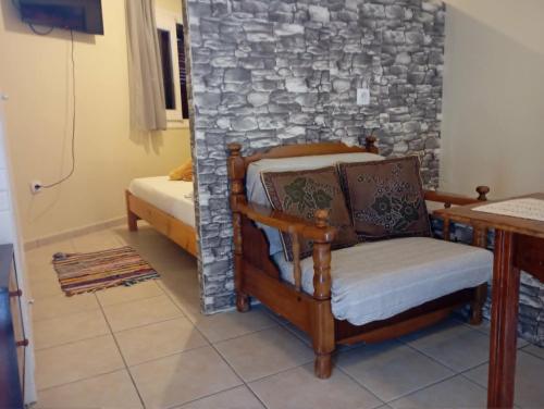 a room with a chair and a stone wall at Villa Vitta picola casa in Nafpaktos
