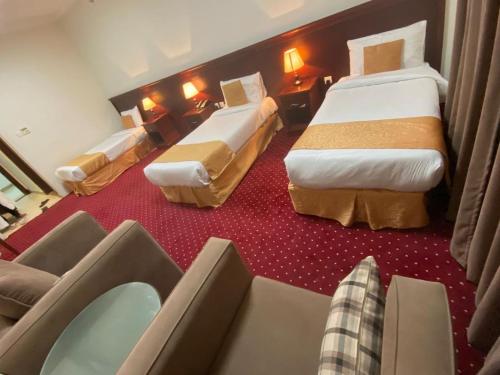 a hotel room with two beds and a couch at فندق ريماس العنود in Mecca