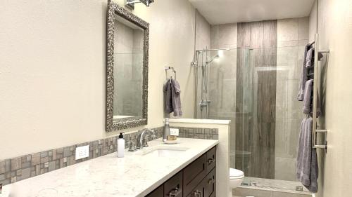 a bathroom with a sink and a shower with a mirror at Sun Valley Adventures Heated Pool & Spa in Ketchum