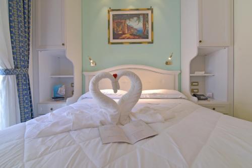 two white swans making a heart on a bed at Hotel Santa Lucia in Minori