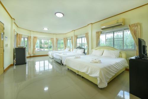 two beds in a large room with windows at Reaunnapa Resort in Ban Nong Kham