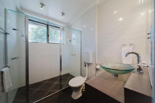 a bathroom with a glass sink and a shower at Flinders 2 bed apartment near the Strand in Townsville
