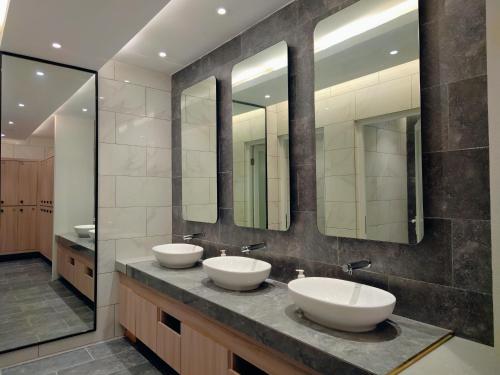 a bathroom with two sinks and two mirrors at Bay Win La,mer Butik in Kota Kinabalu