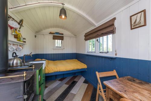 a small room with a bed and a table at Stompy's Hut in Laxfield