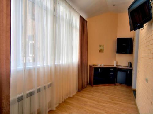a living room with a tv and a window at Sunday Apart Hotel in Kyiv