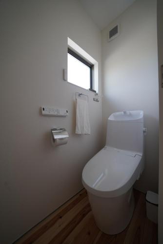 a bathroom with a white toilet and a window at 紀の川みんと間 in Kinokawa