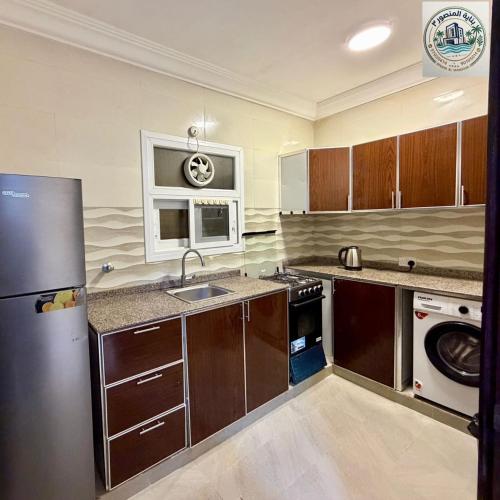 a kitchen with a refrigerator and a sink in it at المنصور 3 in Salalah